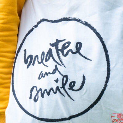 Close-up of Thich Nhat Hanh calligraphy on natural beige cotton tote bag showing brushwork detail