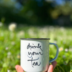 A white Plum Village Enamel Mug with Drink Your Tea calligraphy of Zen Master Thich Nhat Hanh
