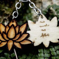 Plum Village Poplar Wood Keychain in lotus shape, laser-engraved with 'No Mud, No Lotus' quote