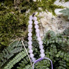 Rose quartz wrist mala close-up, showcasing 27 smooth wooden beads and a sleek adjustable string for a comfortable fit