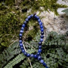 Sodalite wrist mala close-up, showcasing 27 smooth wooden beads and a sleek adjustable string for a comfortable fit