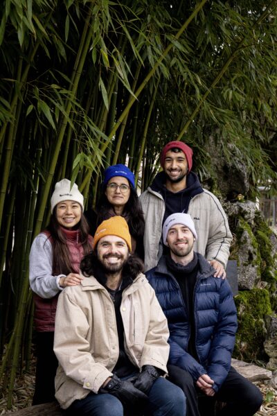 Model wearing the Plum Village organic cotton beanie in a forest setting