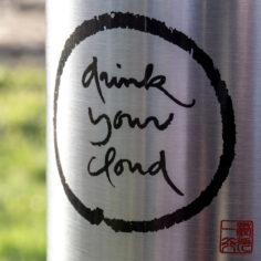 A close up of the Calligraphy "Drink Your Cloud" on the Plum Village Insulated Stainless Steel Water Bottle; Détail de la calligraphie sur la gourde isotherme en acier inoxydable Plum Village