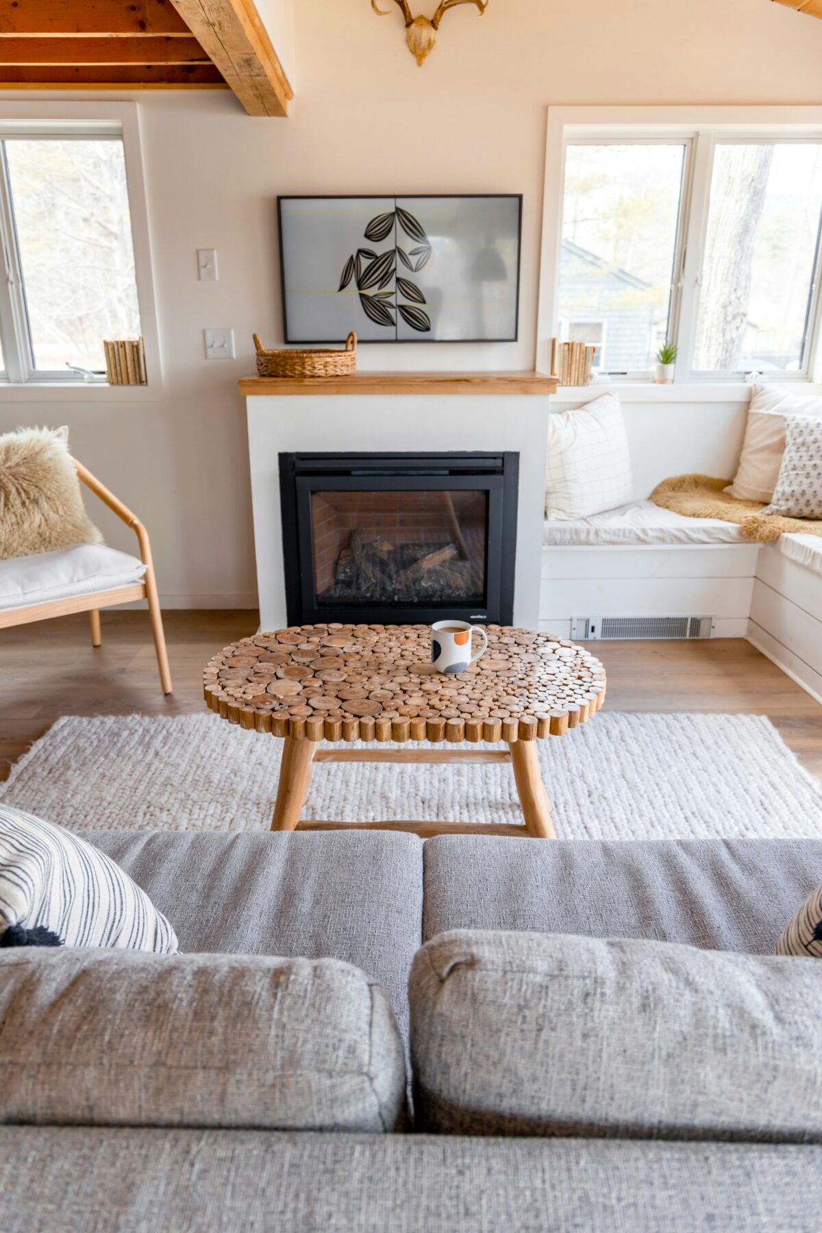 Benefits of no TV in living room shown through mindful meditation corner near fireplace with calligraphy and cushions