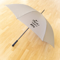 Close-up of A Cloud Never Dies calligraphy on recycled RPET polyester canopy of Plum Village umbrella in gentle light